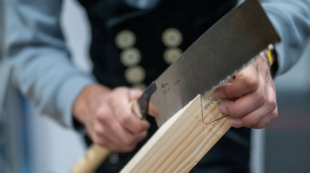 Ein Schreiner auf der Internationalen Handwerksmesse in München 2025. Viele Handwerksbetriebe in Bayern haben trotz real sinkender Umsätze 2025 mehr Azubis eingestellt. (Archiv) / Foto: Leonie Asendorpf/dpa