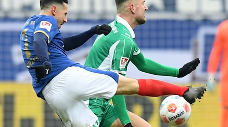 Der Kieler Steven Skrzybski (l) wird vom Fürther Dennis Srbeny geblockt. / Foto: Daniel Bockwoldt/dpa