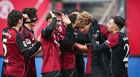 Seine Mitspieler wollen Matchwinner Piet Scobel gar nicht mehr loslassen. / Foto: Daniel Karmann/dpa