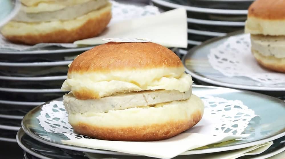 Münchens Wirtschaftsreferent sieht in dem Krapfen eine Art bayerischen Burger. / Foto: -/München TV/dpa