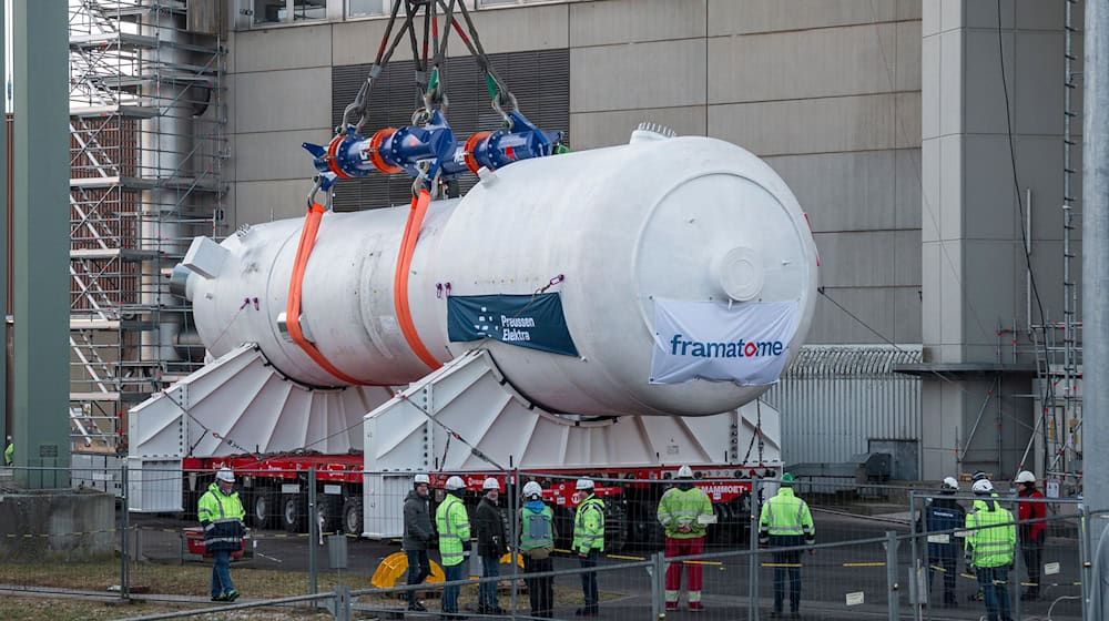 Ein Dampferzeuger wird mithilfe eines Schwerlastkrans aus dem Reaktorgebäude gehoben und auf zwei Träger für den Weitertransport montiert. / Foto: Daniel Vogl/dpa