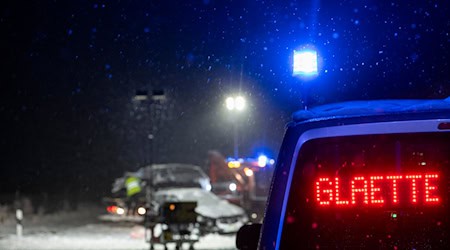 Auf der verschneiten Bundesstraße 12 warnt an einer Unfallstelle ein Polizeifahrzeug vor Glätte. / Foto: Stefan Puchner/dpa