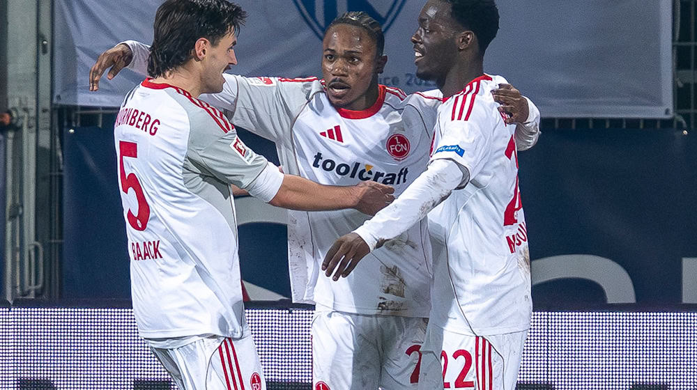 Der Nürnberger Mohamed Alì Zoma (Mitte) bejubelt mit den Vorlagengebern Tom Baack (links) und Rabby Nzingoula seinen Treffer zur 1:0-Führung. / Foto: David Inderlied/dpa