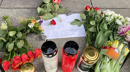 Blumen und Kerzen erinnern an Amel und ihre Tochter Hafsa, die bei dem Anschalg starben. / Foto: Sabine Dobel/dpa