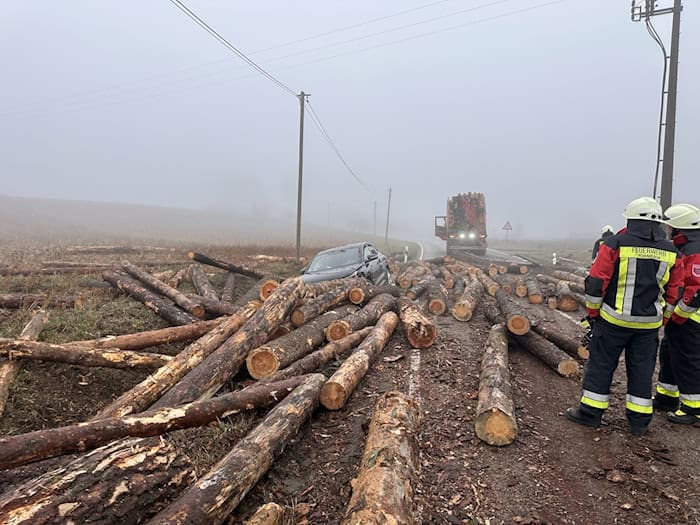 Holzstämme fallen von Laster auf Auto - Insassen unverletzt