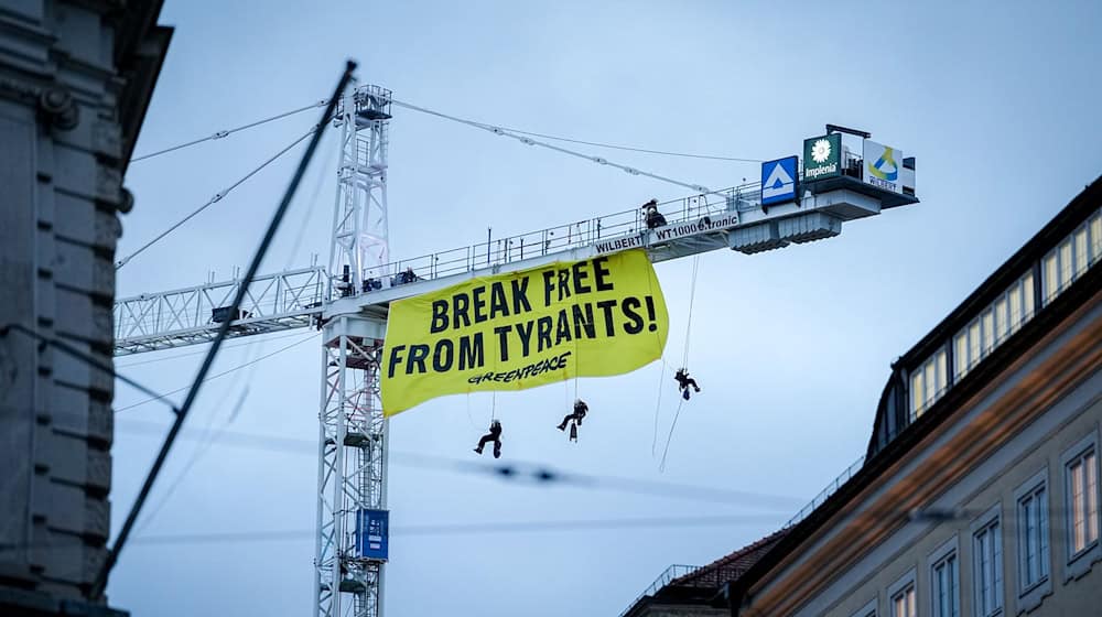 Aktivisten seilen sich von einem Kran in der Nähe der Münchner Sicherheitskonferenz ab. / Foto: Kay Nietfeld/dpa