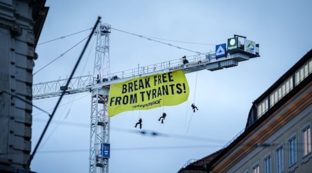 Aktivisten seilen sich von einem Kran in der Nähe der Münchner Sicherheitskonferenz ab. / Foto: Kay Nietfeld/dpa