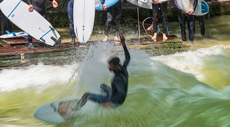 Endlich wieder mit dem Brett auf die Eisbachwelle - darauf hoffen Surferinnen und Surfer in München. (Archivbild) / Foto: Peter Kneffel/dpa