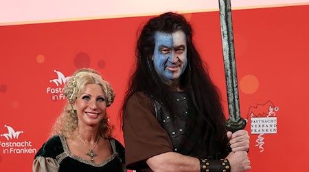 Bayerns Ministerpräsident Markus Söder und seine Frau Karin Baumüller-Söder zeigen sich vor Beginn der Prunksitzung «Fastnacht in Franken» auf dem roten Teppich. / Foto: Daniel Löb/dpa