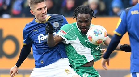 Zweikampf zwischen Marko Ivezic (l, Holstein Kiel) und Noel Futkeu (SpVgg Greuther Fürth). / Foto: Daniel Bockwoldt/dpa