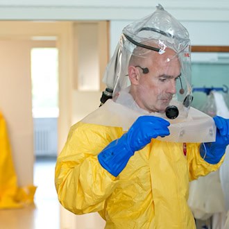 In Schutzanzügen arbeiten die Ärzte auf der Sonderisolierstation am Patienten. (Archivbild) / Foto: picture alliance / dpa