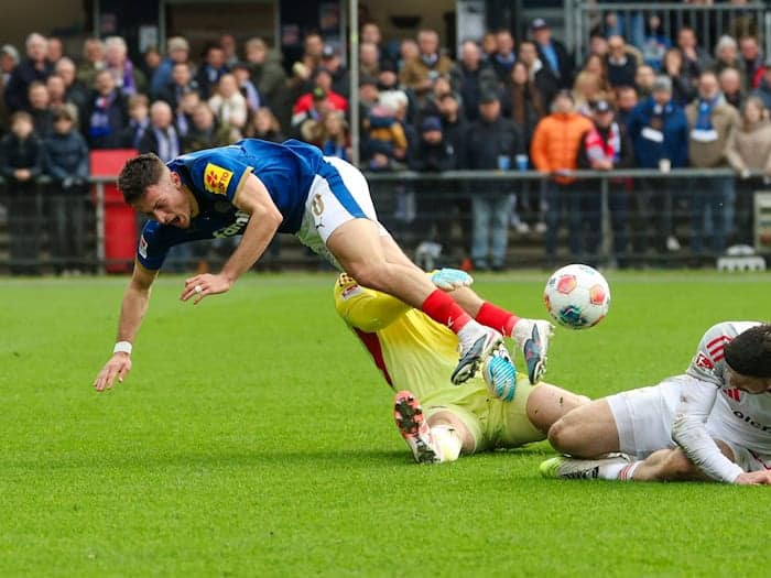 Kiels Adrian Kapralik (l) prallt mit Nürnbergs Jan Reichert zusammen. / Foto: Frank Molter/dpa