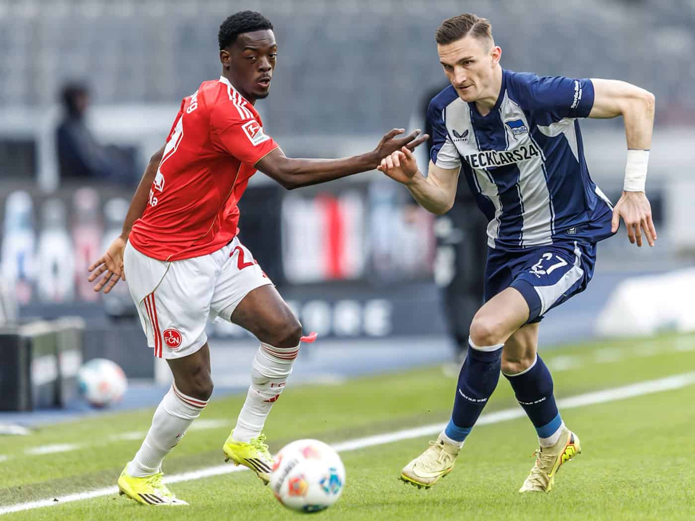 Nürnbergs Rabby Nzingoula im Zweikampf mit Herthas Niklas Kolbe. / Foto: Andreas Gora/dpa