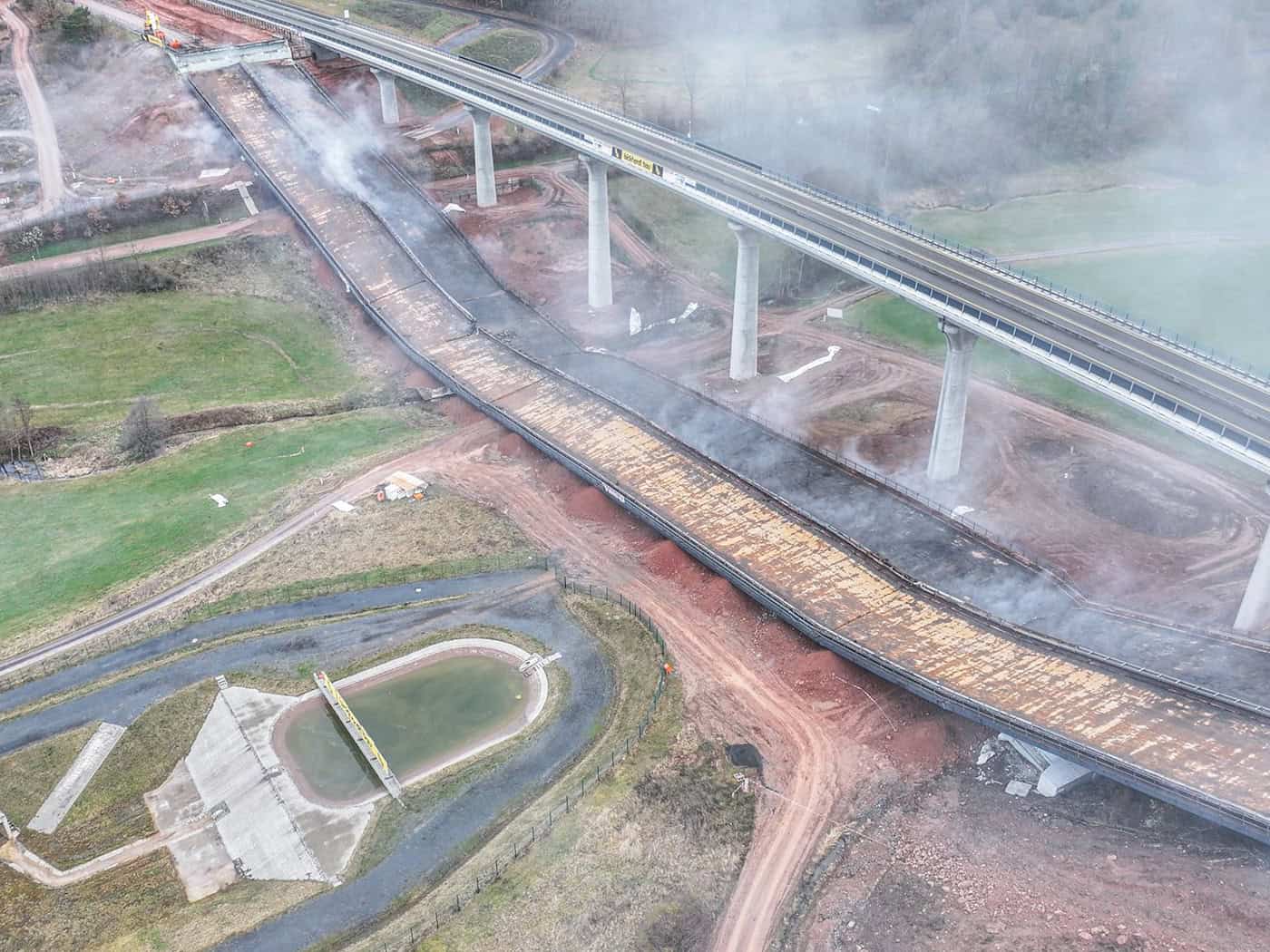 Nach der Sprengung liegen die Brückenteile am Boden. / Foto: Jason Tschepljakow/dpa