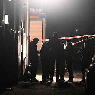 Polizeibeamte, Kriminalpolizei, Spurensicherung und Staatsanwaltschaft stehen vor einem Haus, in dem eine Frau tot aufgefunden worden war. / Foto: Felix Hörhager/dpa