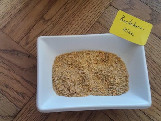 Bockshornklee-Samen in einer Schale mit handschriftlich beschriftetem Etikett ‚Bockshornklee‘ – ein natürliches Heilmittel in ganzer Form.
