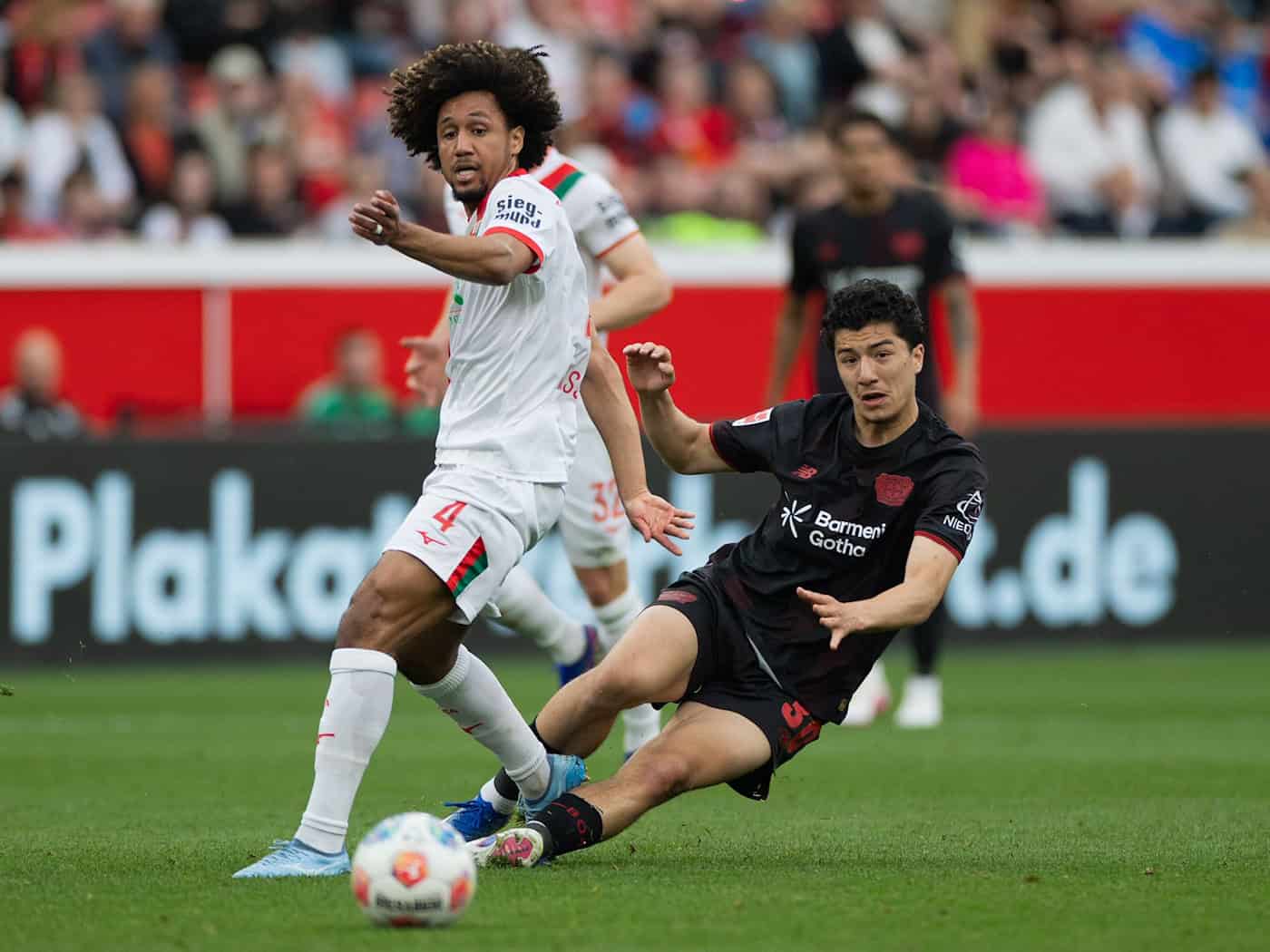 Leverkusens Ibrahim Maza im Duell mit Augsburgs Han-Noah Massengo.  / Foto: Rolf Vennenbernd/dpa