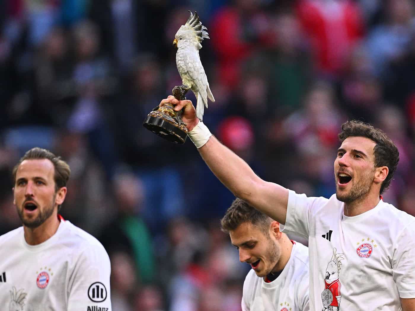 Leon Goretzka zeigt den Kakadu. / Foto: Tom Weller/dpa