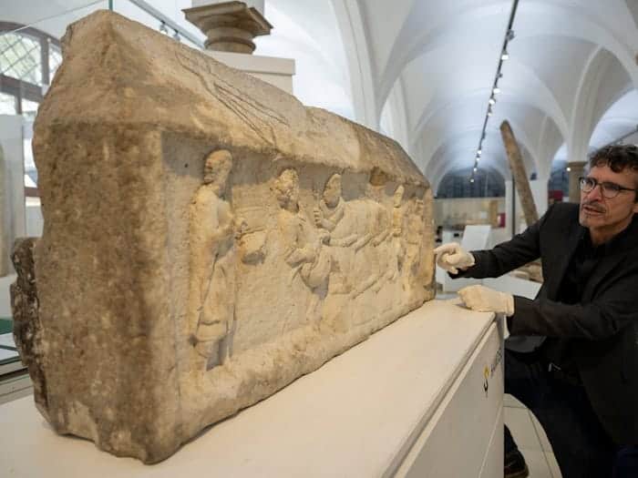 Augsburgs Stadtarchäologe Sebastian Gairhos zeigt ein römisches Grabrelief, das Ende des Jahres bei einer großen Ausstellung in Rom präsentiert werden soll. (Archivbild) / Foto: Stefan Puchner/dpa
