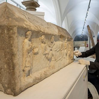 Augsburgs Stadtarchäologe Sebastian Gairhos zeigt ein römisches Grabrelief, das Ende des Jahres bei einer großen Ausstellung in Rom präsentiert werden soll. (Archivbild) / Foto: Stefan Puchner/dpa