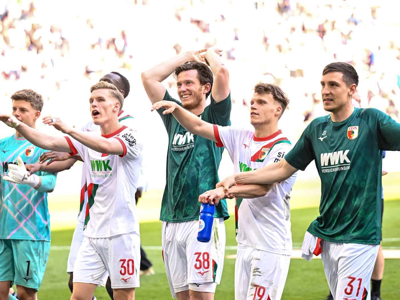 Die Augsburger lassen sich nach dem Sieg über Mönchengladbach feiern. / Foto: Harry Langer/dpa