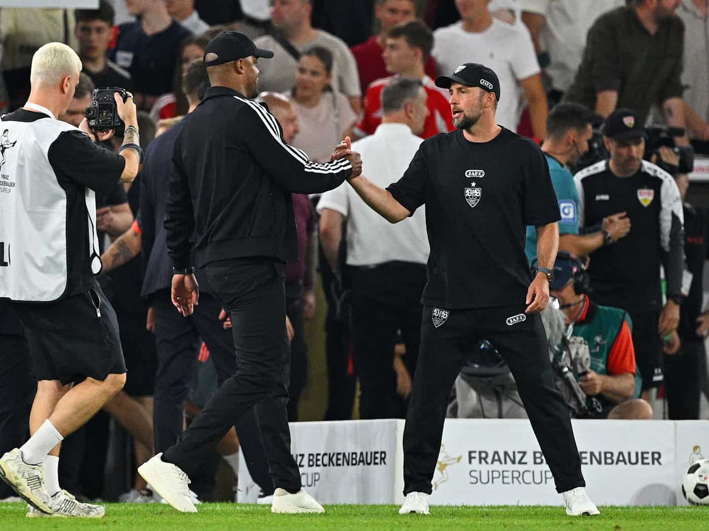 Shake Hands der Trainer Vincent Kompany (l) und Sebastian Hoeneß nach dem Supercup-Duell zu Saisonbeginn. (Archivbild) / Foto: Tom Weller/dpa