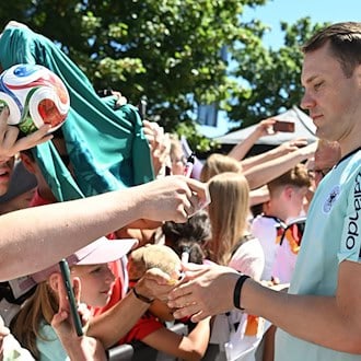 Manuel Neuer schreibt Autogramme für die DFB-Fans.  / Foto: Federico Gambarini/dpa