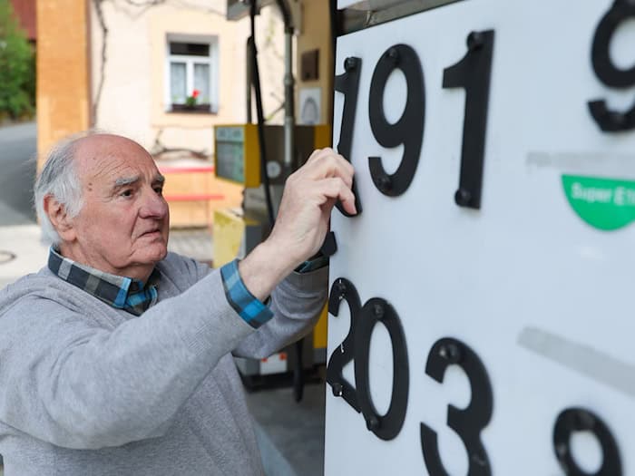 Herbert Brendel passt die Preisanzeige noch händisch an.  / Foto: Daniel Löb/dpa