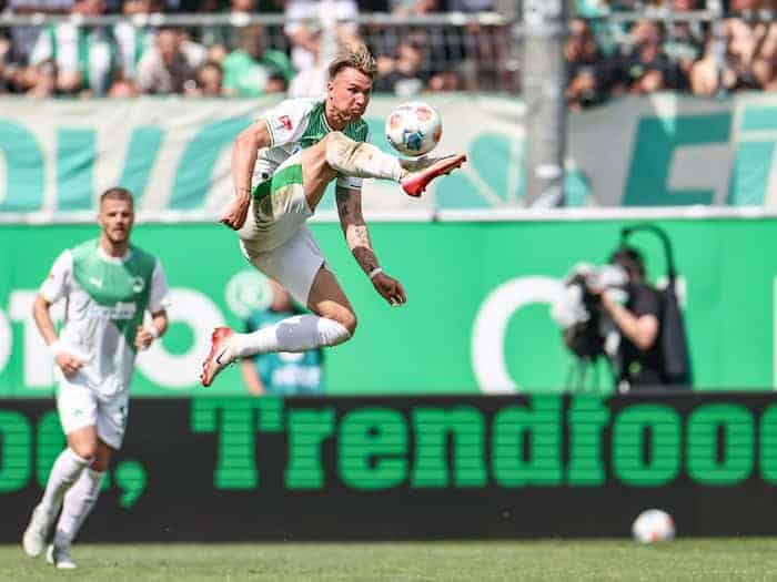 Voller Einsatz im Derby: Fürths Felix Klaus nimmt den Ball artistisch in der Luft an.  / Foto: Daniel Löb/dpa