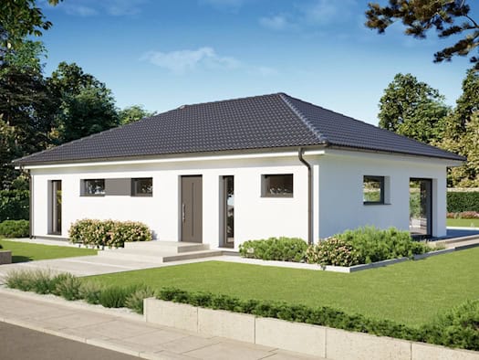 Modernes, weißes Fertighaus-Bungalow mit dunklem Satteldach, großen Fenstern und gepflegtem Garten unter blauem Himmel."
