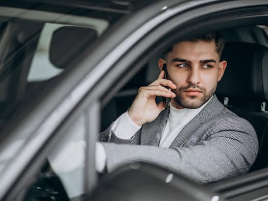Detektiv im Auto am Telefon während einer Observation