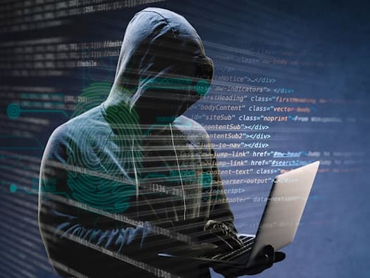 Hacker mit Laptop vor Code-Hintergrund
