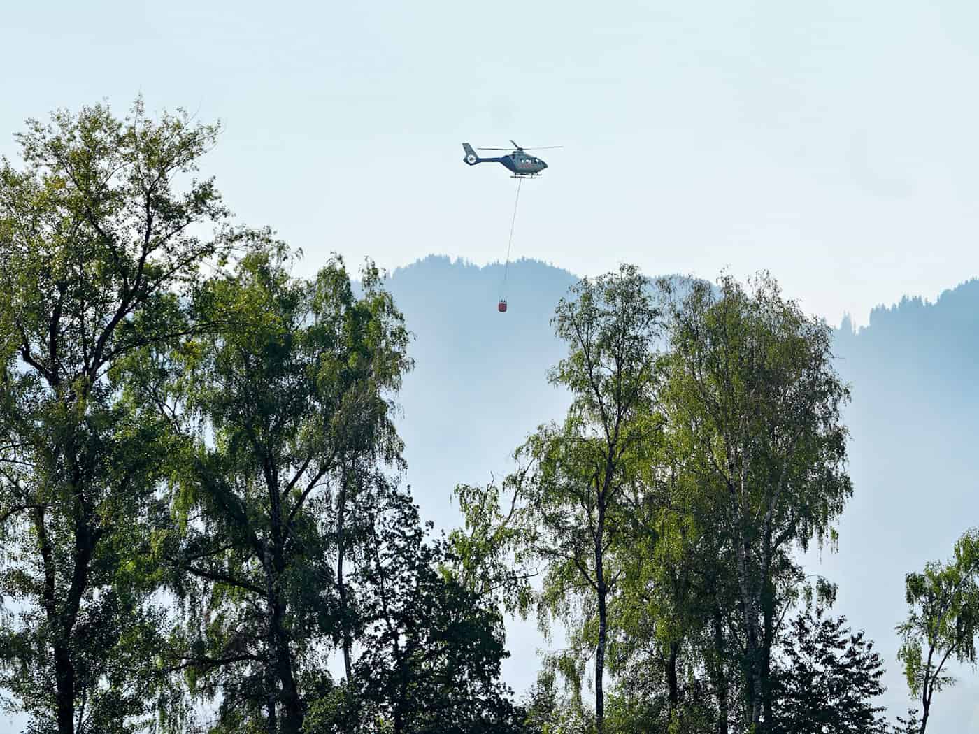 Auch mit einem Hubschrauber versuchen Einsatzkräfte die Flammen zu löschen.  / Foto: Uwe Lein/dpa