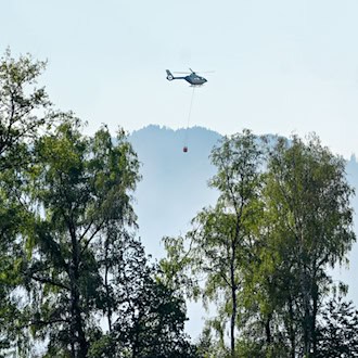 Auch mit einem Hubschrauber versuchen Einsatzkräfte die Flammen zu löschen.  / Foto: Uwe Lein/dpa