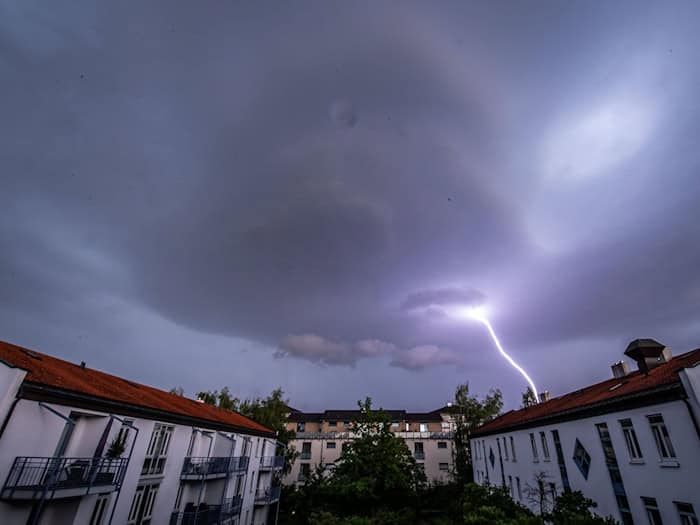 Ein Gewitter über einer Wohnsiedlung. (Symbolbild) / Foto: Lino Mirgeler/dpa