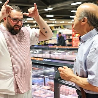 Metzger Yevgeniy Klibanov zeigt die Gebärde für «Rind».  / Foto: Daniel Löb/dpa