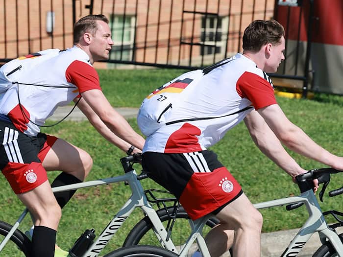 Immer Seite an Seite, auch auf der Fahrt zum Training. Manuel Neuer (l) und Jonas Urbig.   / Foto: Jan Woitas/dpa