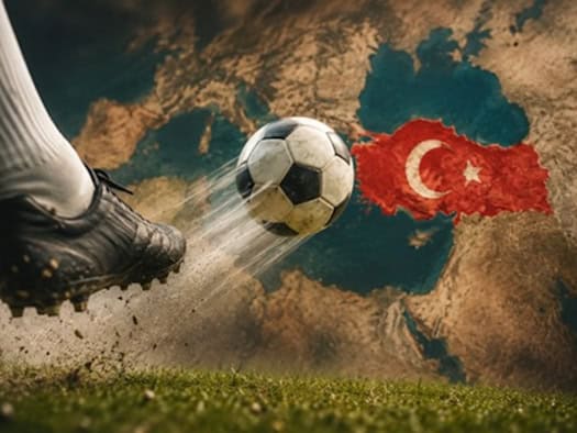 Fußballschuh tritt gegen einen Fußball, im Hintergrund ist die türkische Flagge mit Sichel und Stern auf einer Landkarte der Türkei zu sehen.