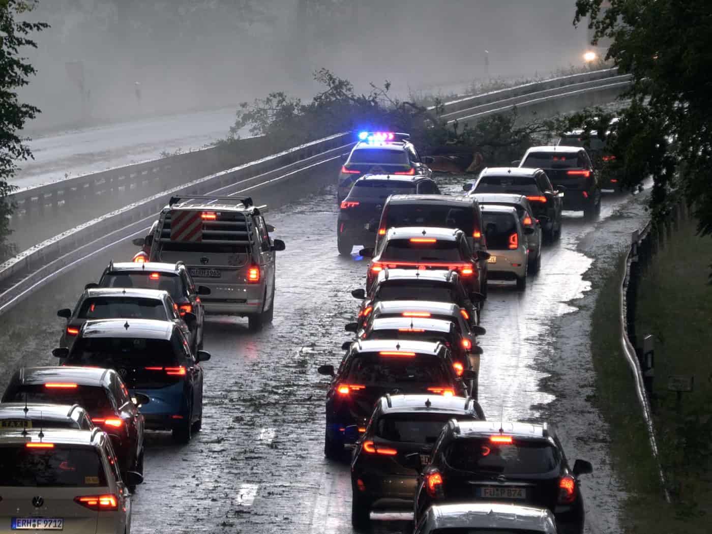 Die Polizei leitet den Verkehr auf der Bundesstraße 4 bei Erlangen-Tennenlohe an umgestürzten Bäumen vorbei. / Foto: Bernd März/Fotoreportextremwetter.tv/dpa