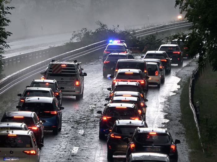 Die Polizei leitet den Verkehr auf der Bundesstraße 4 bei Erlangen-Tennenlohe an umgestürzten Bäumen vorbei. / Foto: Bernd März/Fotoreportextremwetter.tv/dpa