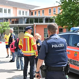 Einsatzkräfte von Polizei und Rettungsdiensten stehen vor dem Welfen-Gymnasium. / Foto: Lennart Preiss/dpa