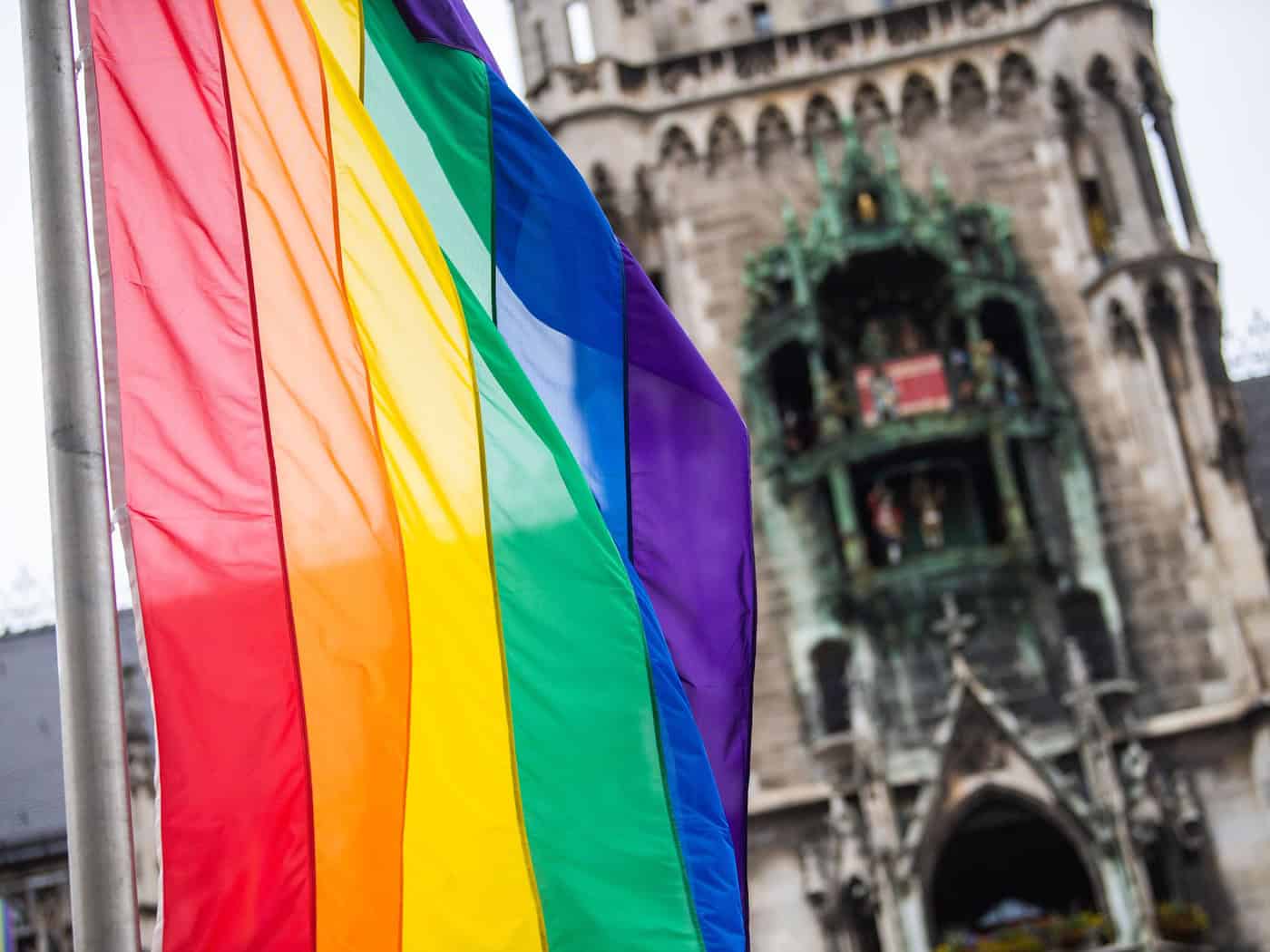 Als Zeichen der Solidarität wehen vor dem Münchner Rathaus Regenbogenflaggen. (Archivbild) / Foto: Lino Mirgeler/dpa