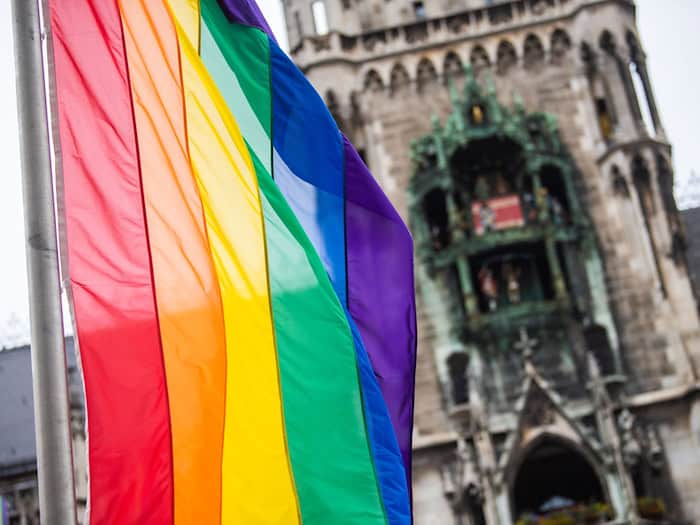 Als Zeichen der Solidarität wehen vor dem Münchner Rathaus Regenbogenflaggen. (Archivbild) / Foto: Lino Mirgeler/dpa