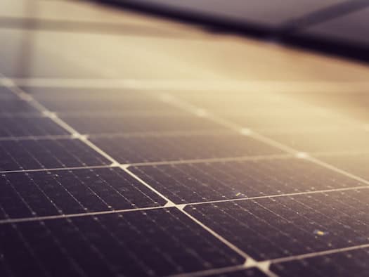 Nahaufnahme eines PV-Moduls mit sichtbaren Solarzellen, die im Sonnenlicht glänzen.