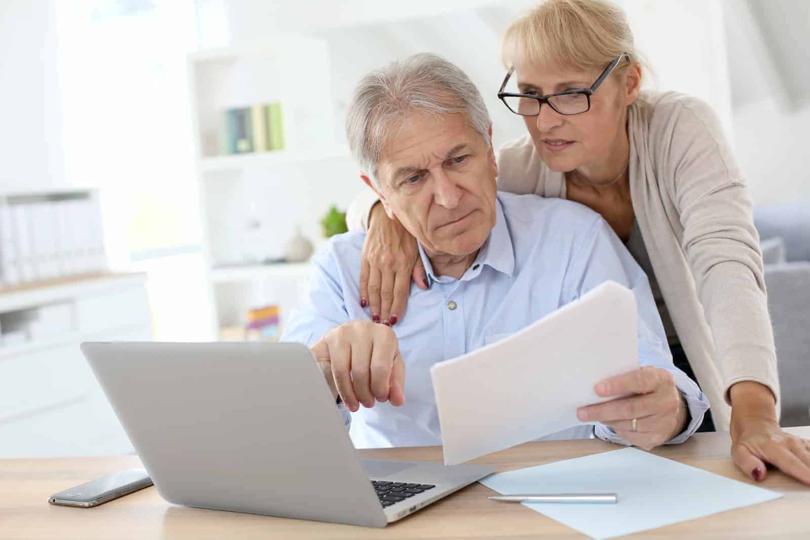 Ehepaar am Laptop mit Unterlagen