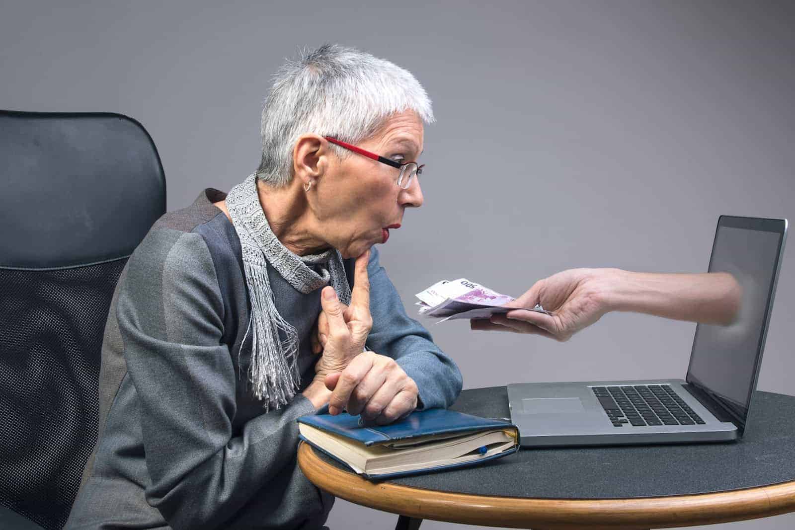 Ältere Frau sitzt am Computer.