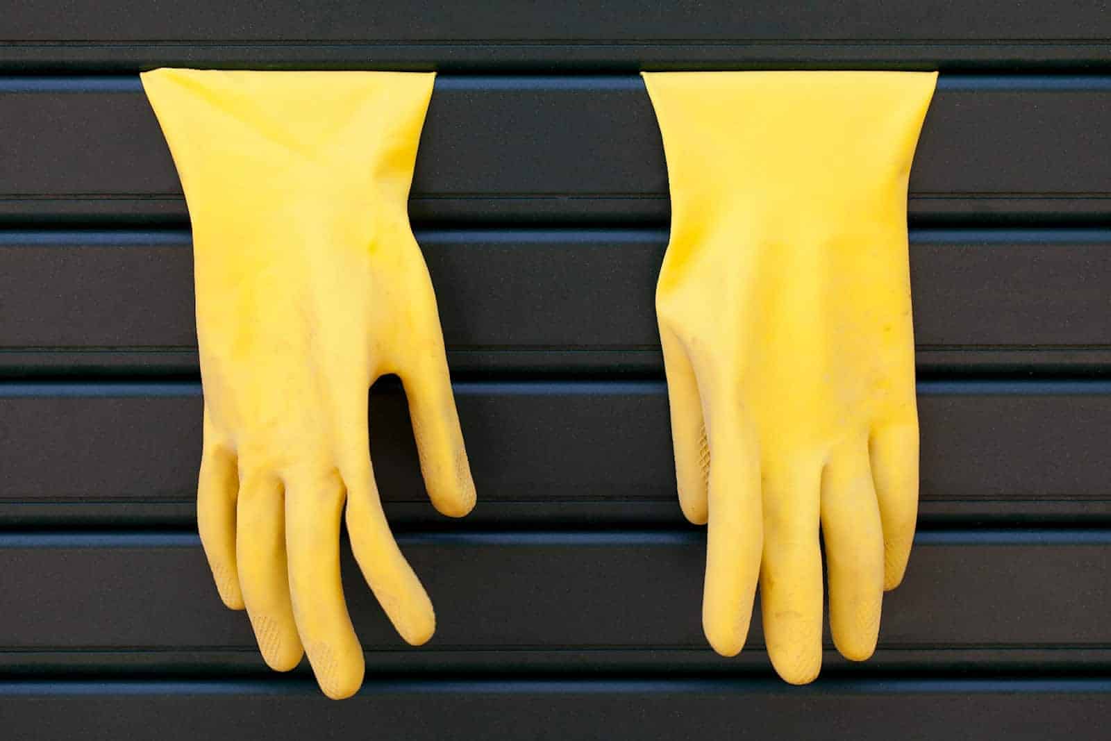 Gelbe Spülhandschuhe hängen an Rolläden.