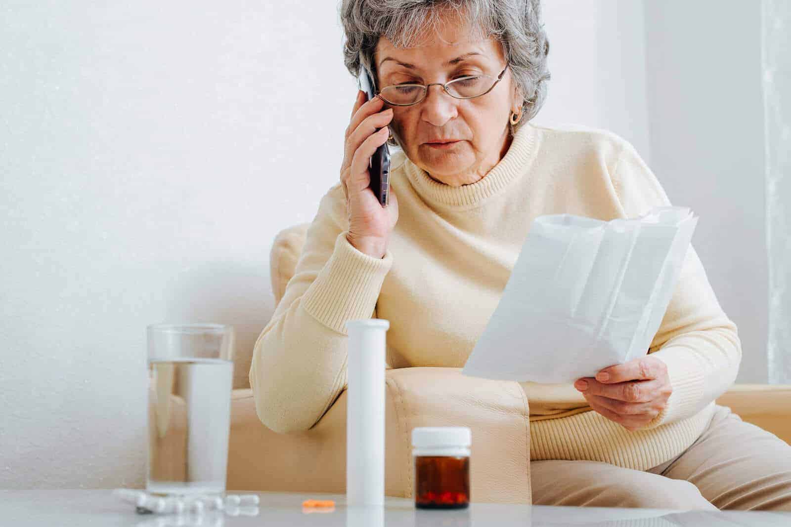 Seniorin holt sich Rat am Telefon.