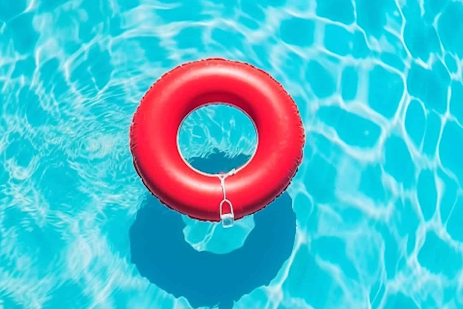 Ein roter Rettungsring liegt in einem kristallklaren Pool.