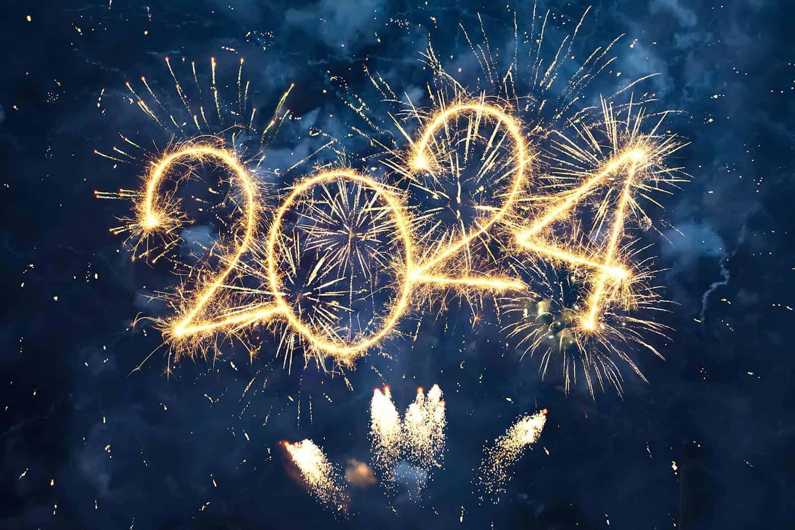 An einem nachtblauen Himmel zeichnet sich goldenes Feuerwerk ab und formt die Zahl 2024. Foto: AdobeStock,lumikk555